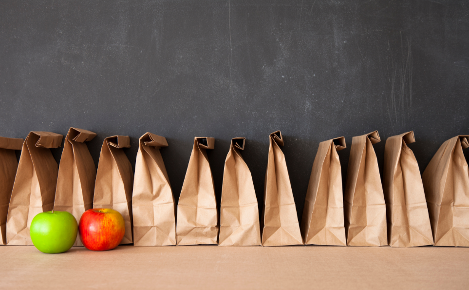 Sack lunches in a row with apples